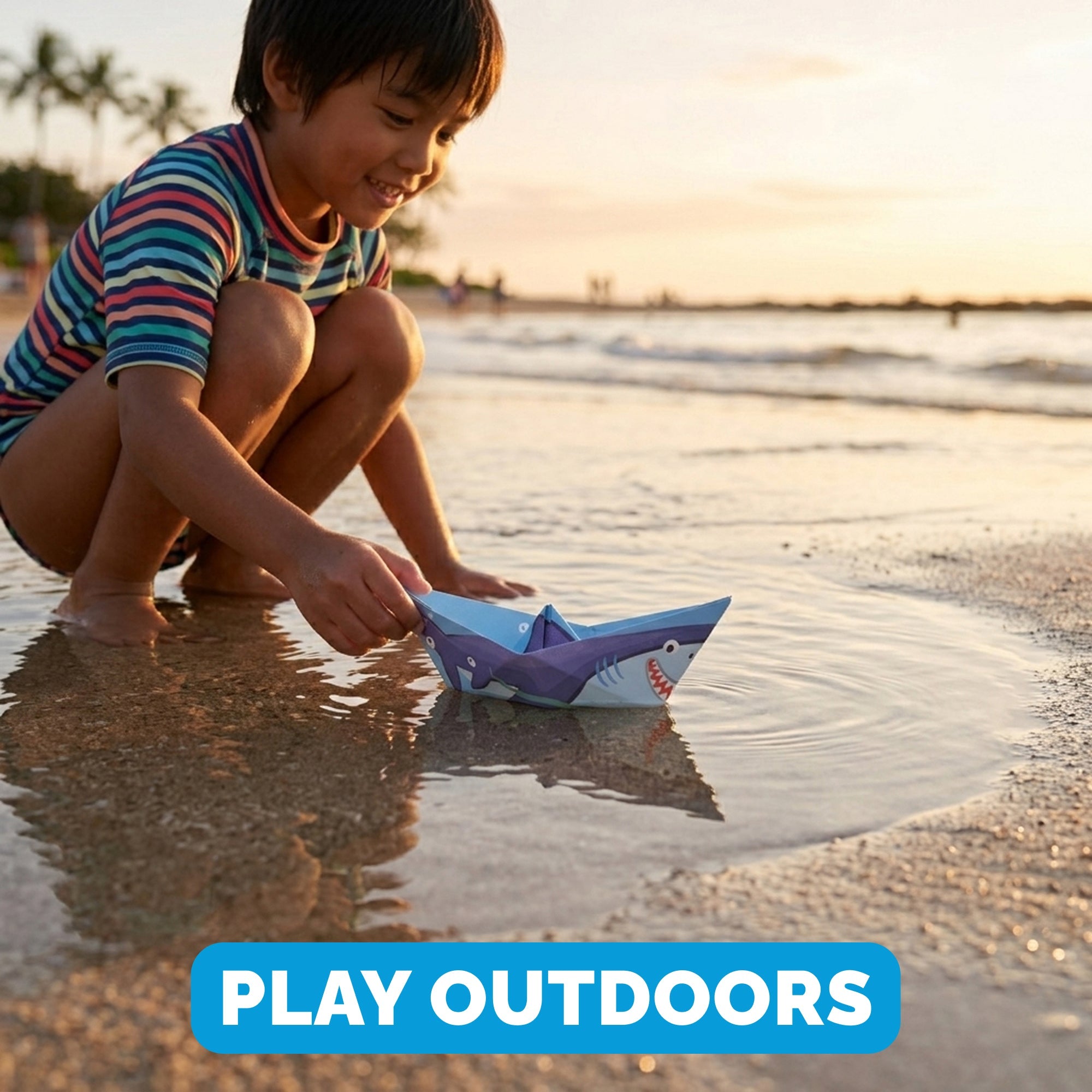 Child playing with a WOYS Savannah Set origami paper boat outdoors at the beach