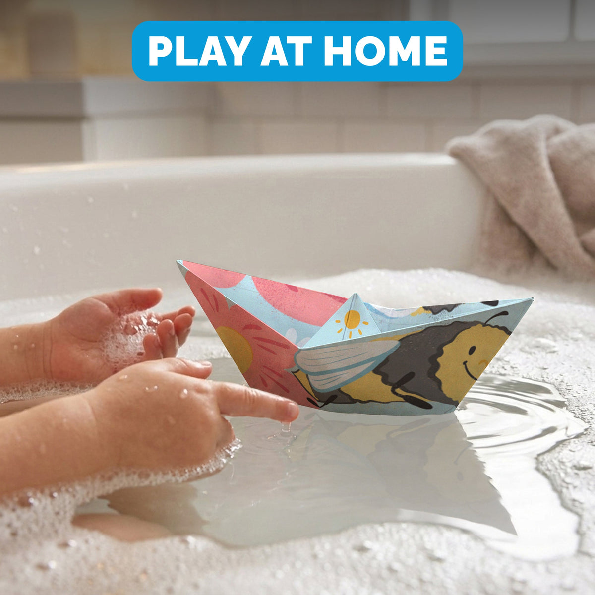 Child floating a WOYS Insects paper boat in the bath