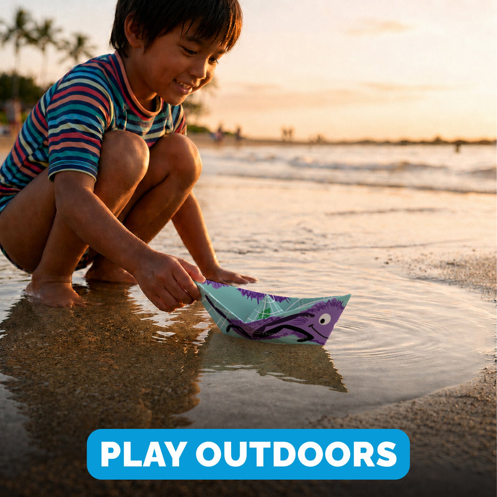 Child playing with a WOYS Insects paper boat outdoors
