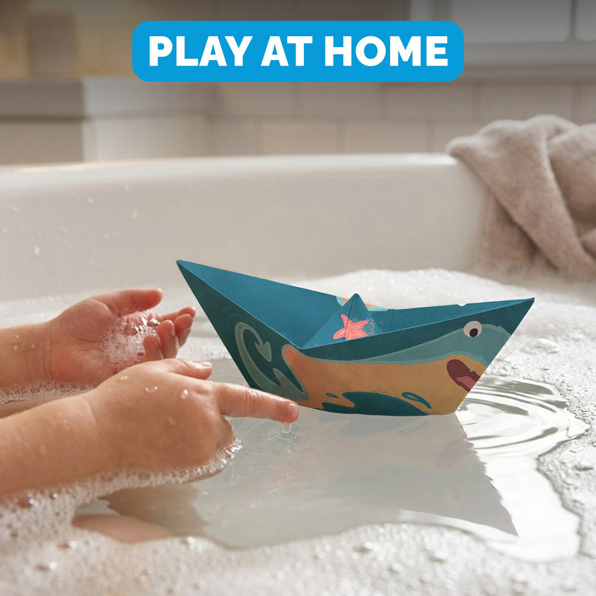 Child floating a WOYS Marine paper boat in the bath