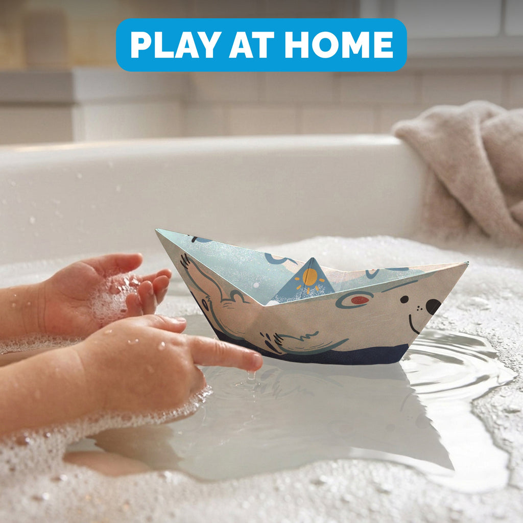 Child floating a WOYS North paper boat in the bath