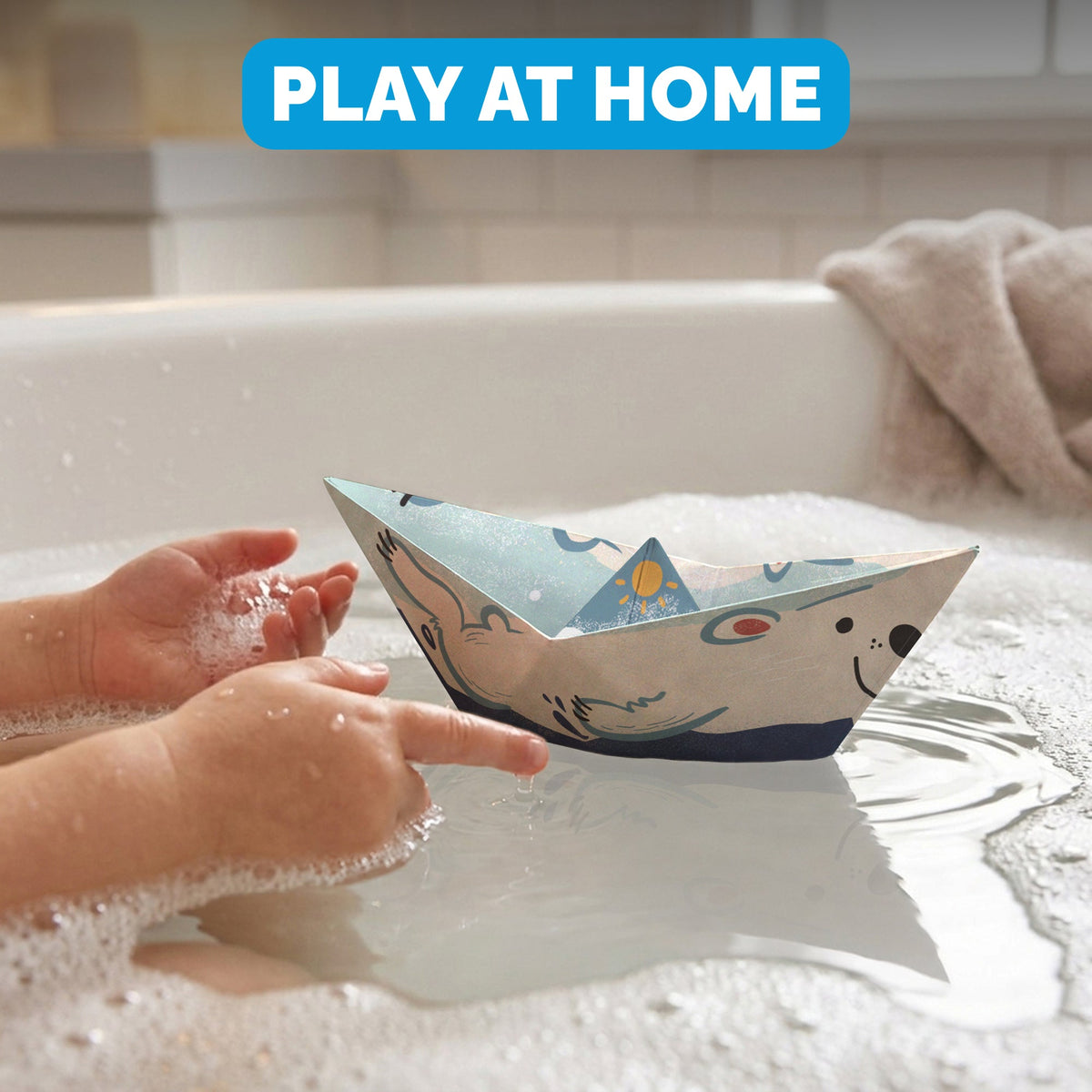 Child floating a WOYS North paper boat in the bath